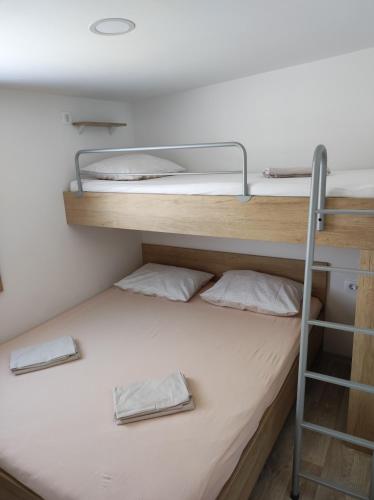 two bunk beds in a room with a ladder at Mobile homes King, Camp Dida in Pirovac
