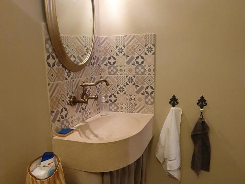 a bathroom with a sink and a mirror at Escapade de charme près de Verdun : cocon pour 2 personnes avec cuisine équipée et balades à proximité - FR-1-585-85 in Souilly