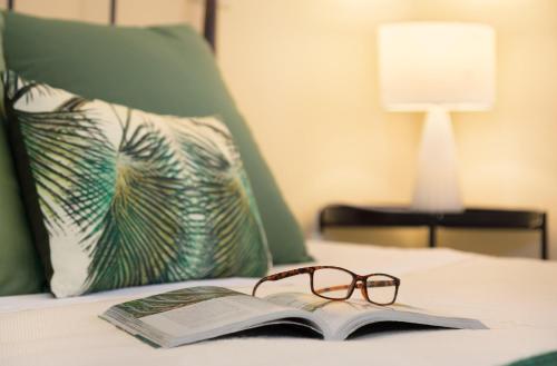 a book and a pair of glasses sitting on a bed at Chelubirdi in Villasimius