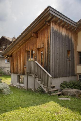 a wooden house with a staircase in front of it at Landstrasse 153 in Klosters