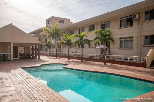 a swimming pool in front of a building at Cozumel 206 in Umdloti