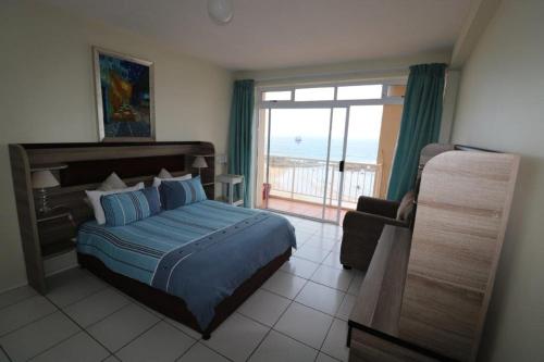 a bedroom with a bed and a view of the ocean at Cozumel 206 in Umdloti