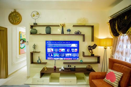 a living room with a flat screen tv on a wall at Kiki's Home and Apartments in Magboro-Akeran