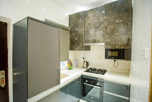 a kitchen with a stainless steel refrigerator and a stove at Kiki's Home and Apartments in Magboro-Akeran