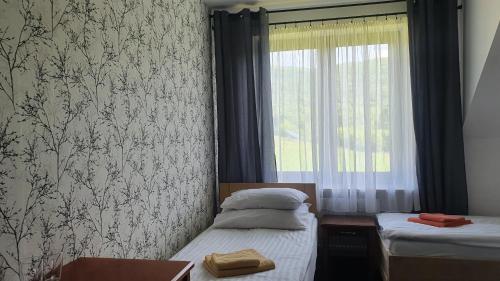 a bedroom with two twin beds and a window at ŁOMIANKOWA DOLINA Wetlina 112 in Wetlina