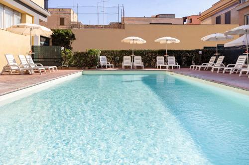 ein großer Pool mit Stühlen und Sonnenschirmen in der Unterkunft Hotel Villa Margherita in Ladispoli