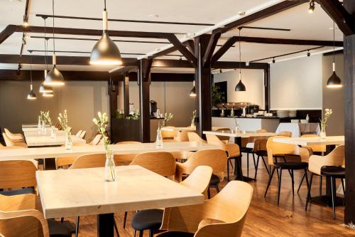 a restaurant with tables and chairs and a kitchen at Hotelli Havu in Uusikaupunki