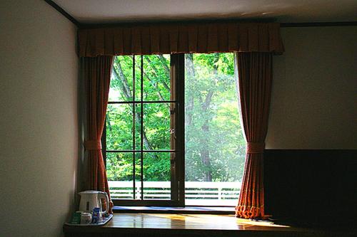a window in a room with a view of a yard at Pension Marieペンションマリエ in Yamanakako