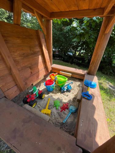 a sandbox with toys in the sand in a wooden house at U Lipińskich - Dom nad jeziorem in Ostrzyce