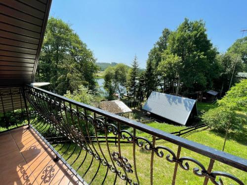 a balcony of a house with a view of a yard at U Lipińskich - Dom nad jeziorem in Ostrzyce