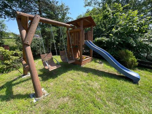 a playground with a slide in the grass at U Lipińskich - Dom nad jeziorem in Ostrzyce
