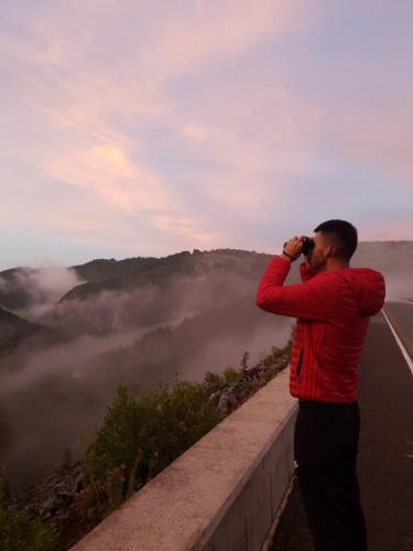 a man taking a picture of a mountain with a camera at Apartman Teodora Uvac in Nova Varoš