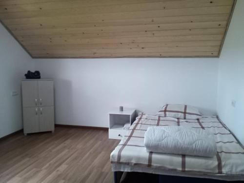 a bedroom with a large bed with a wooden ceiling at Apartman Teodora Uvac in Nova Varoš