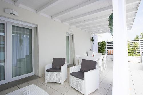 a balcony with white chairs and a table on a patio at Residence Armony in Misano Adriatico