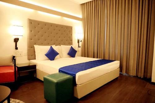 a bedroom with a large bed with blue pillows at Hotel Deccan Serai Grande, Gachibowli, Hyderabad in Hyderabad