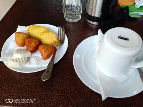 ein Tisch mit zwei Tellern Essen und einer Tasse Kaffee in der Unterkunft NdamaRosa River Park Resort in Migori