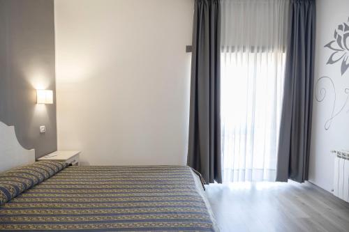 a hotel room with a bed and a window at Hotel Villa Margherita in Ladispoli