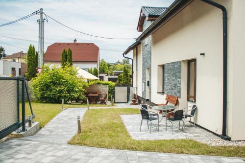 eine Terrasse mit einem Tisch und Stühlen neben einem Haus in der Unterkunft apartmány U Solišů in Klimkovice