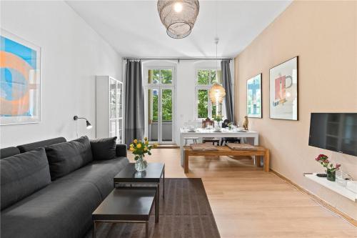 a living room with a couch and a table at Holiday 33 Apartments EFG Schönhauser Allee mit Balkon in Berlin