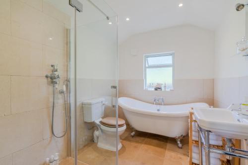 La salle de bains est pourvue d'une baignoire, de toilettes et d'un lavabo. dans l'établissement Bluebell Cottage, à Chippenham