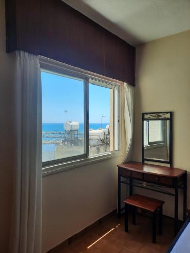 a room with a window and a table and a mirror at Seascape 501 in Larnaca