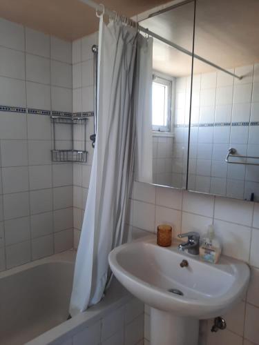 a bathroom with a sink and a tub and a mirror at Seascape 501 in Larnaca