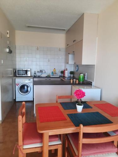 a kitchen with a wooden table with chairs and a dining room at Seascape 501 in Larnaca