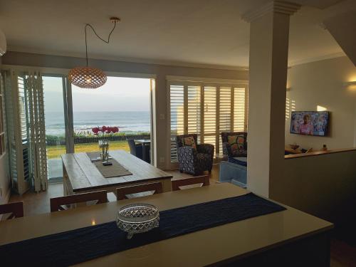 Modern & Luxurious Beachfront Villa في باليتو: غرفة معيشة مع طاولة وإطلالة على المحيط