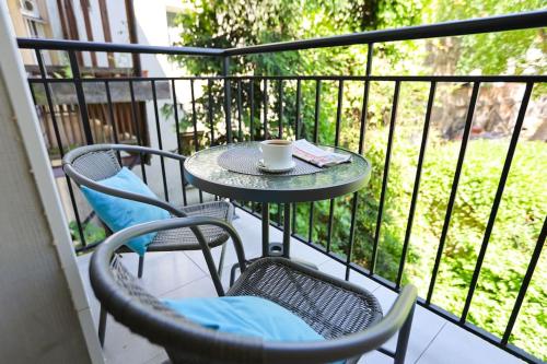a table and chairs on a balcony with a cup of coffee at DReAM Post Aparthotel in Kraków