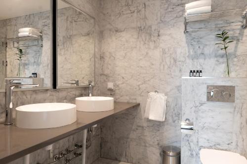 a bathroom with two sinks and a mirror at Elite Stadshotellet Växjö in Växjö