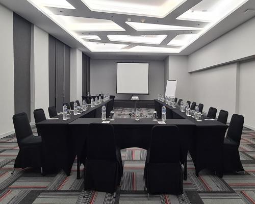 a conference room with a long table and chairs at Asyana Kemayoran Jakarta in Jakarta