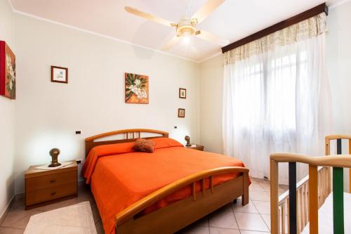 1 dormitorio con 1 cama y ventilador de techo en Case Vacanza Aiosardegna, en Pula