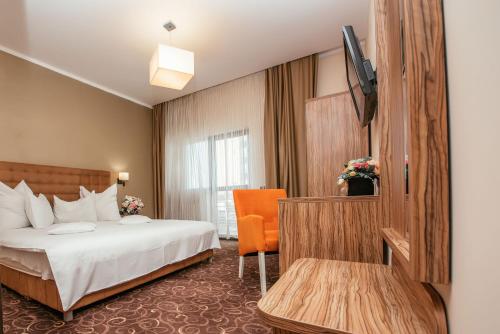 a hotel room with a bed and a television at C Guest House in Drobeta-Turnu Severin