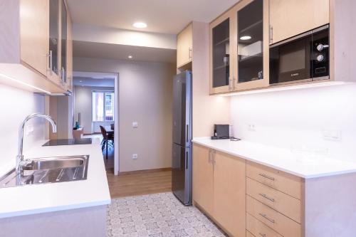 una cucina con lavello e frigorifero di HERITAGE APARTMENTS CERDANYA al carrer Major i parking a Puigcerdà