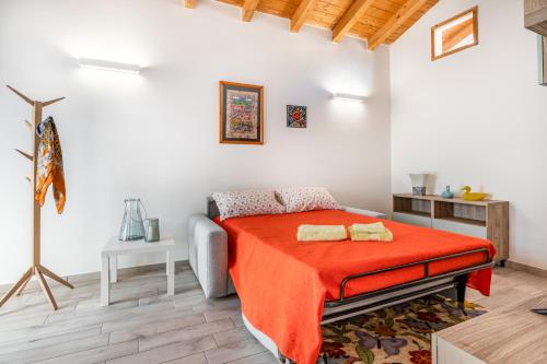 sypialnia z łóżkiem z pomarańczowym kocem w obiekcie Casenuove Viletta Indipendente a 10 min da Parma w mieście Case Nuove