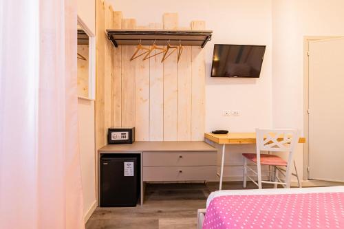 a small bedroom with a desk and a table at Hotel Majorca in Gabicce Mare