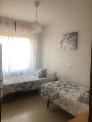 1 dormitorio con 2 camas y ventana en Donde Juanita, en Salamanca