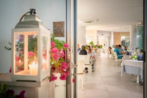 a dining room with people sitting at tables in a restaurant at International Beach Hotel in Caorle