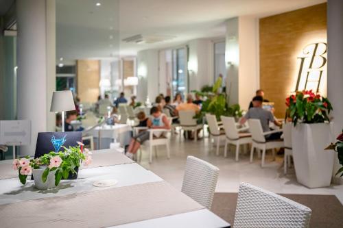 a restaurant with tables and chairs and people in the background at International Beach Hotel in Caorle