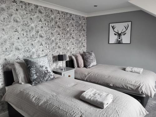a bedroom with two beds and a deer on the wall at The Admiral's Rest in Scarborough