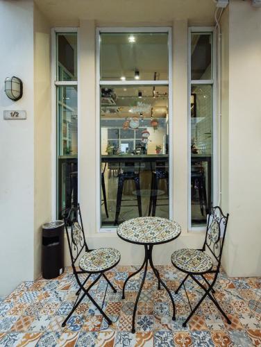 two chairs and a table in front of a store at SLEEP TO FLY HOTEL & HOSTEL suvarnabhumi airport in Bangkok