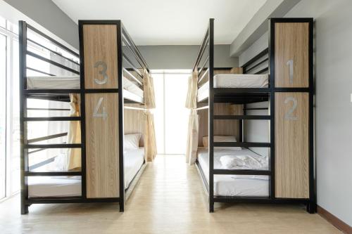 a room with three bunk beds in a room at SLEEP TO FLY HOTEL & HOSTEL suvarnabhumi airport in Bangkok