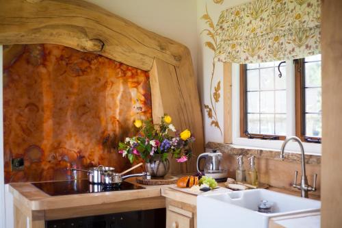 una cucina con lavandino e parete in legno di The Queen Bee Cabin a Hereford