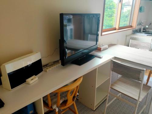 a desk with a computer and a monitor on it at Apartment House Akita in Akita