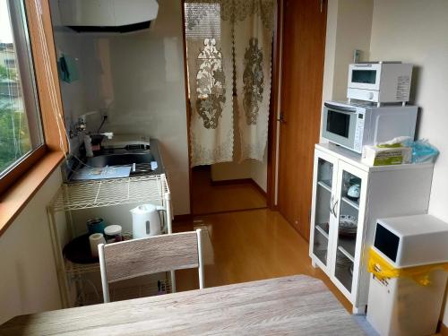a kitchen with a sink and a microwave on a counter at Apartment House Akita in Akita