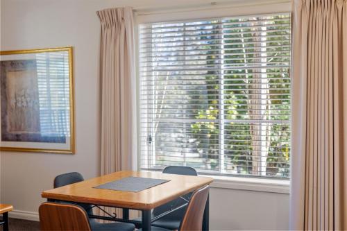 a dining room with a table and a large window at Yarra Gables in Healesville