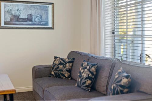 a couch with pillows in a living room at Yarra Gables in Healesville