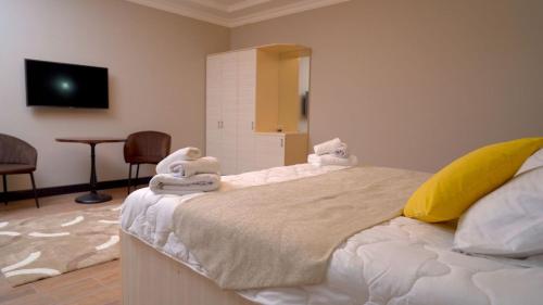a bedroom with a bed with towels on it at Edem Hotel Shymkent in Shymkent