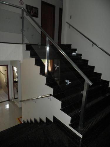 a staircase in a house with a glass railing at Hotel Talismã in Rondonópolis