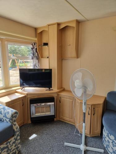 a small living room with a fan and a tv at Pod bocianim gniazdem in Węgorzewo